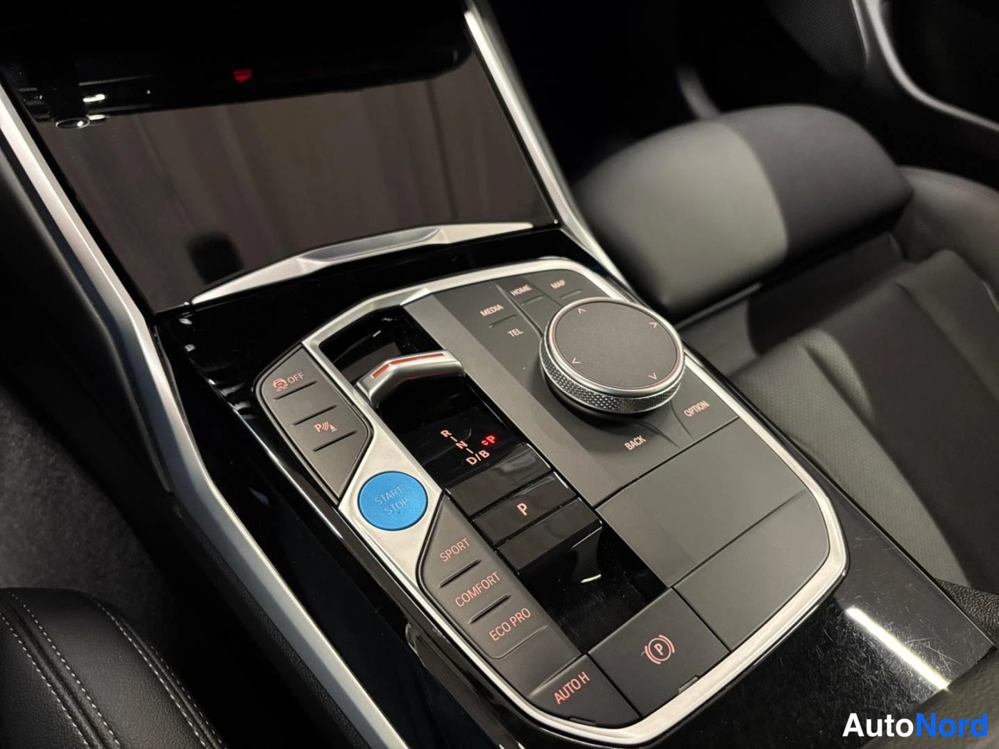 Yksityiskohta: Auton keskitunnelin säädinkonsoli lähikuvassa: vaihteenvalitsin P, pyöreä iDrive-säädin ja ajotilapainiket SPORT, COMFORT, ECO PRO.