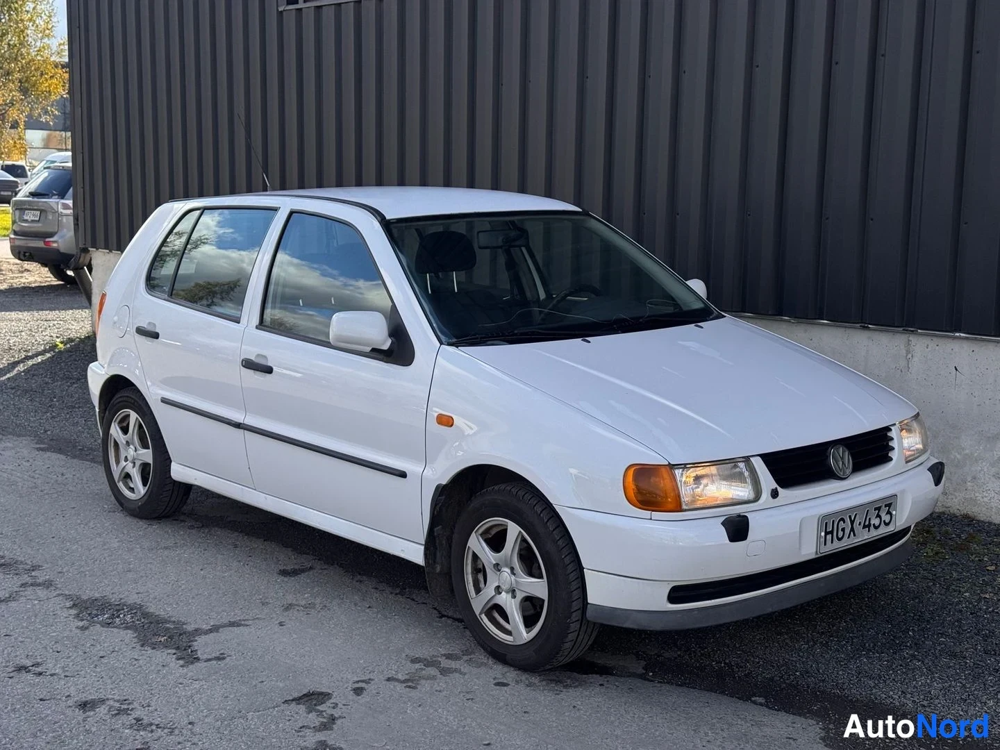 Etuviisto, nokka oikealle: Valkoinen viisiovinen Volkswagen Polo etuviistosta oikealta, rekisterikilpi.