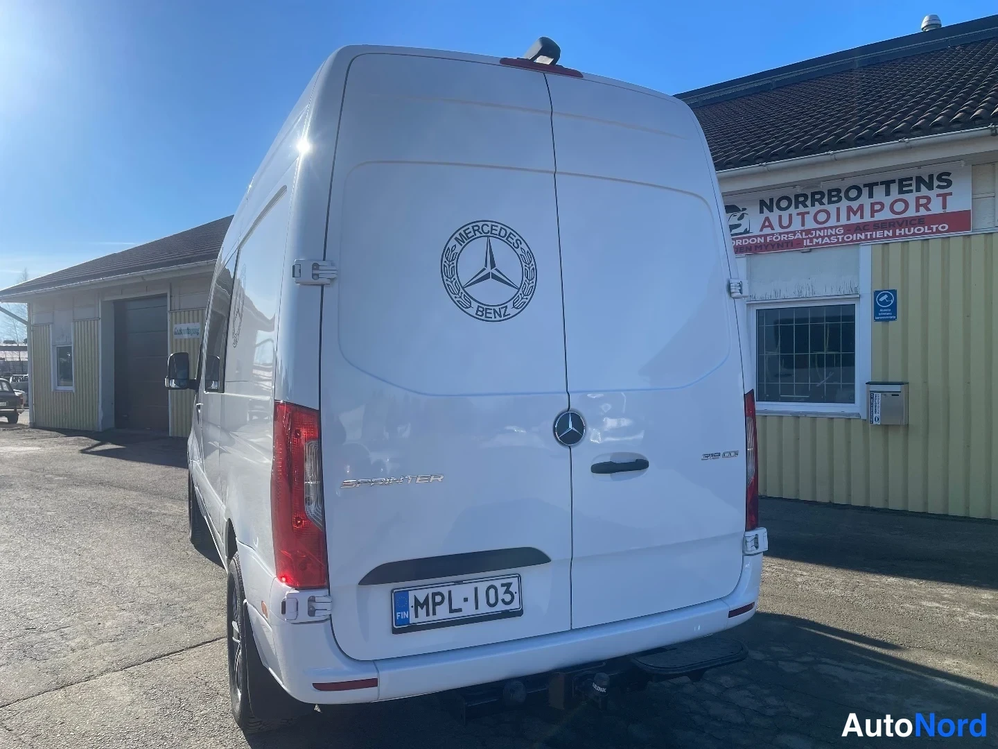 Takaa: Valkoinen Mercedes-Benz Sprinter suoraan takaa, rekisteritunnus.