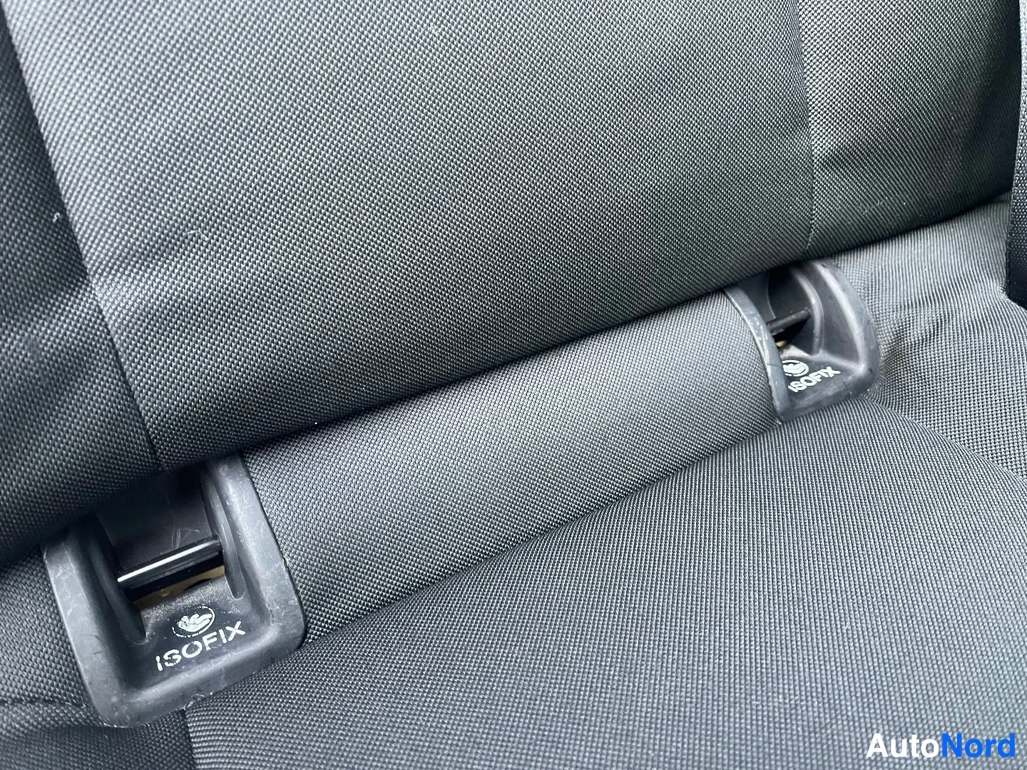 Yksityiskohta: Mustan kankaan istuimen selkänoja, jossa näkyvät ISOFIX-kiinnikkeet.