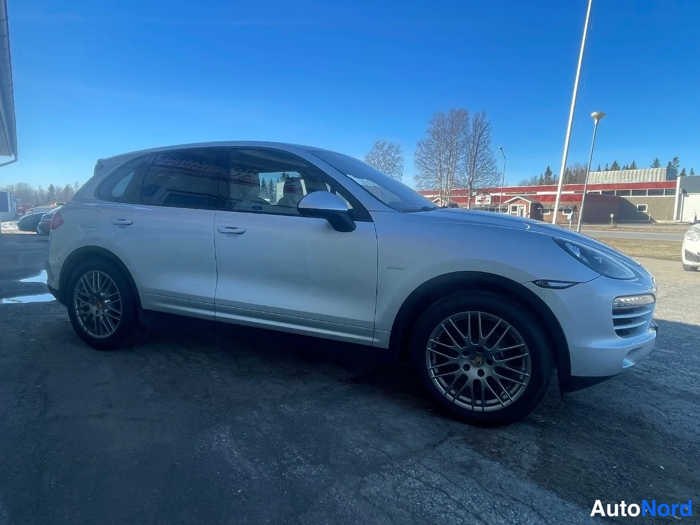 Etuviisto, nokka oikealle: Hopea tilava tilava SUV sivulta kuvattuna, keula kuvan oikeassa reunassa.