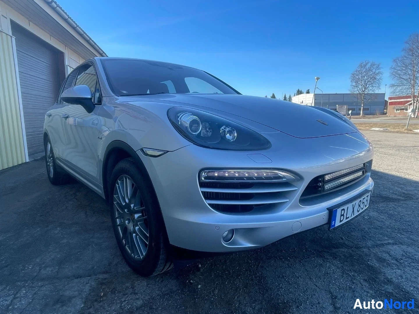 Etuviisto, nokka oikealle: Hopeainen Porsche Cayenne etuviistöstä oikealta, rekisterikilpi BLX 853.