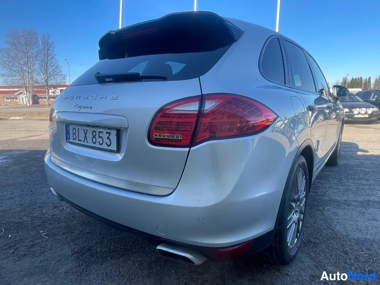 Takaviisto: Hopeanharmaa Porsche Cayenne takaa vasemmalta kuvattuna, rekisterikilpi BLX 853.
