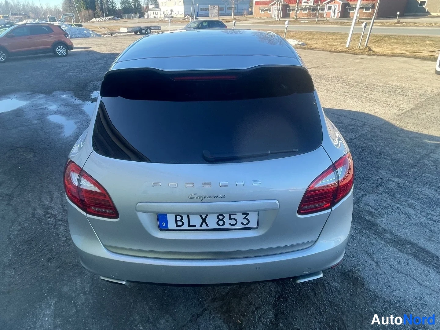 Takaa: Porsche Cayennen takapäätä suoraan takaa: hopea kori, Porsche- ja Cayenne-tekstit bootin kannella ja rekisterikilpi BLX 853.