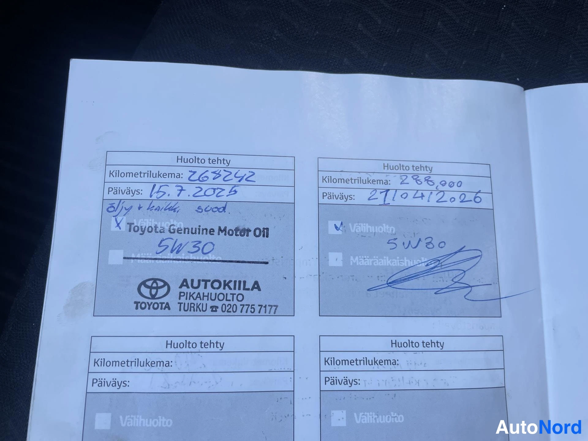 Yksityiskohta: Huoltokirjan sivu, jossa tuoreita huoltomerkintöjä kilometreillä 263242 ja 286000.