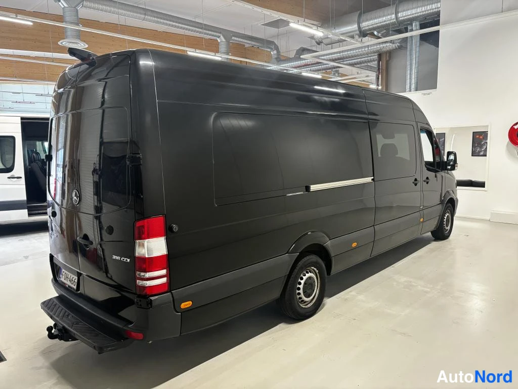 Takaviisto: Mercedes-Benz Sprinter -pakettiauto takaa ylhäältä hieman oikealta kuvattuna, musta kori ja hinnaustraulinen takapuskuri