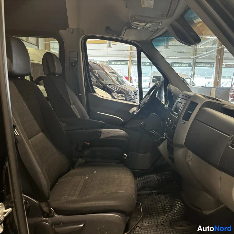 Muu: Mercedes-Benz Sprinter -pakettiauton ohjaamo sivulta katsottuna; kaksi etuistuinta, kojelauta ja radioyksikkö näkyvät.