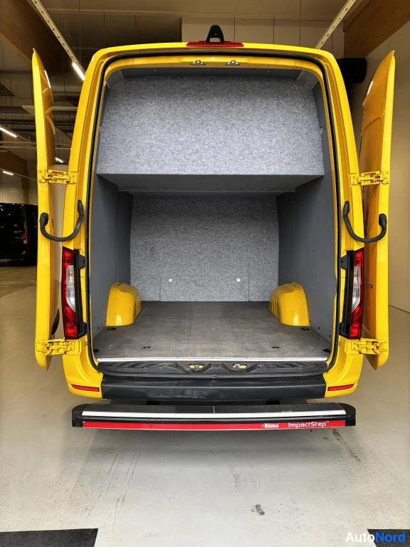 Takaa: Keltainen pakettiauto takaa, tavaratilan ovet auki