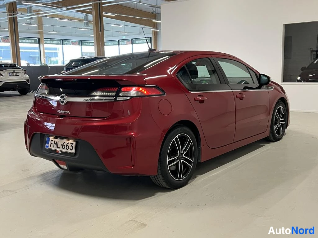 Takaviisto: Punainen Opel Ampera -henkilöauto takaviistosta sisätiloissa, rekisterikilpi
