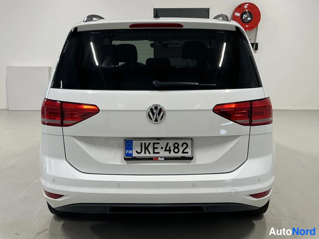 Takaa: Valkoisen Volkswagen Touranin takanäkymä; rekisterikilpi.