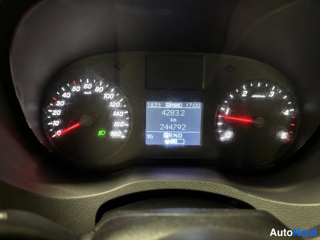 Sivulta: Ajoneuvon mittarist lähikuva: nopeusmittari, kierrosmittari ja näyttö, jossa kokonaisajomäärä 244792 km.