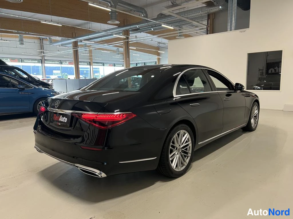 Takaviisto: Musta Mercedes-Benz S-luokan sedan näkyvissä takaa-vinosta, takavalot ja kylki näkyvissä autotallissa.