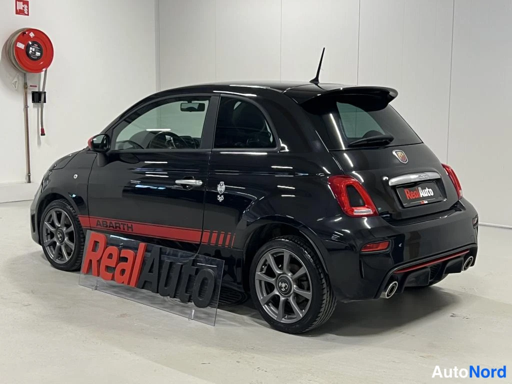 Takaviisto: Mustan Abarth 500:n takakulma sisätiloissa, punainen kylkilista.