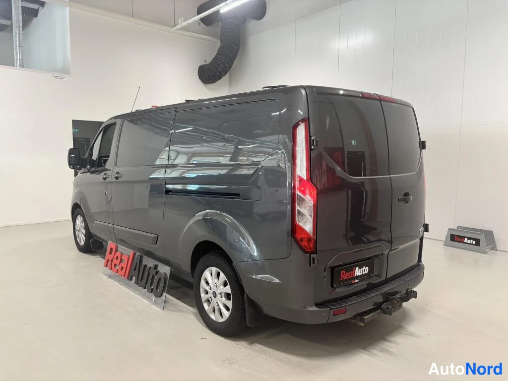 Takaviisto: Pakettiauto takaa-sivulta kuvattuna, tummanharmaa kori ja vetokoukku takapuskurissa.