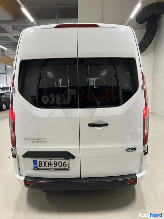 Takaa: Valkoisen Ford Transit Custom -pakettiauton takaosa suoraan takaa; kaksoistakaluukut, takavalot, Ford-merkki ja rekisterikilpi näkyvät.