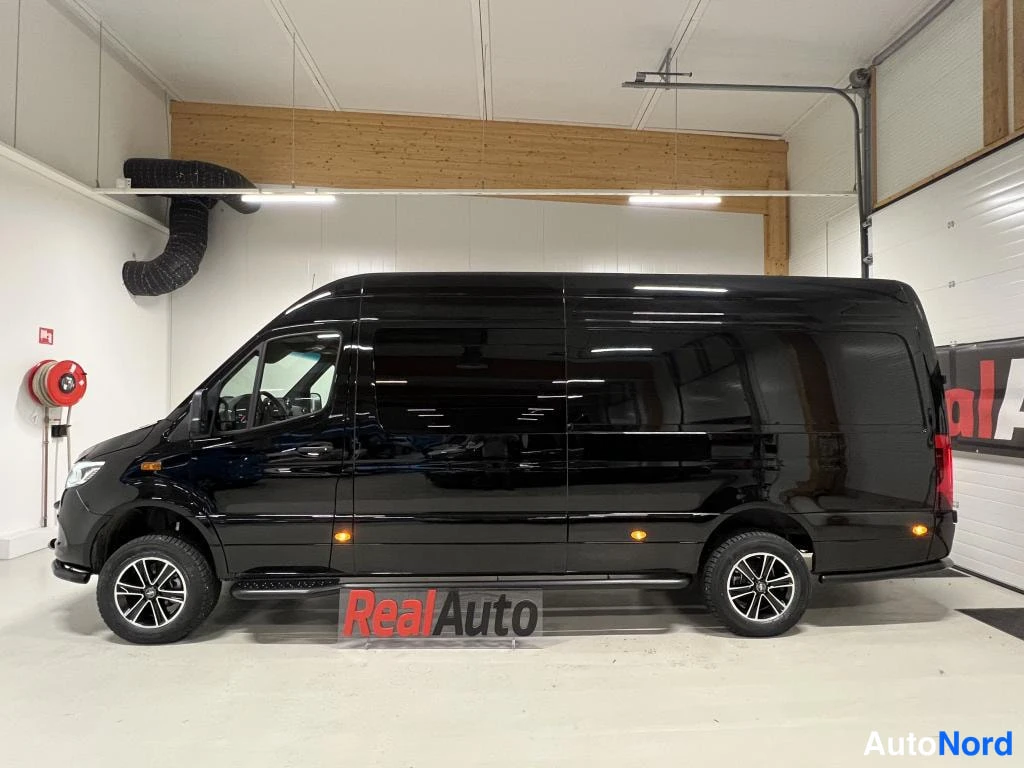 Sivulta: Musta Mercedes-Benz Sprinter -pakettiauto sivusuunnasta, kylki ja pyörät kokonaan näkyvissä.