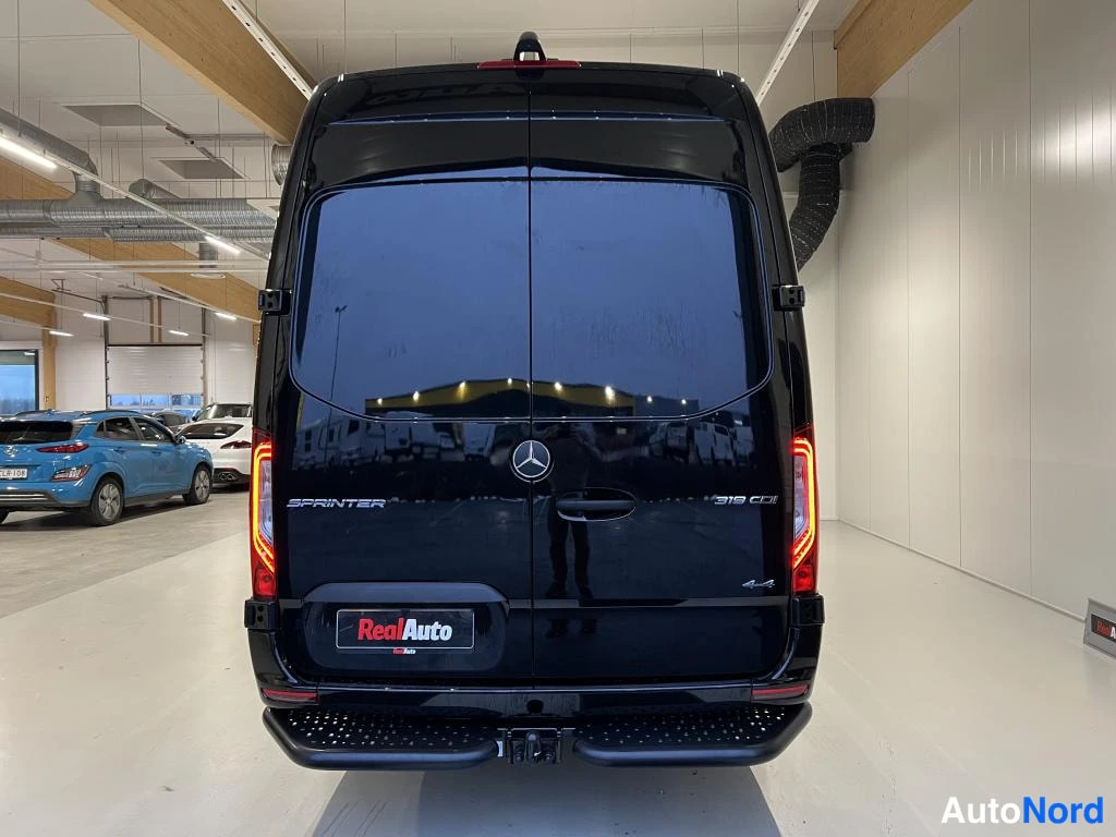 Takaa: Mercedes-Benz Sprinter 319 CDI -pakettiauton takapää suoraan takaa kuvattuna, takaluukussa Mercedes-tähtimerkki ja mallikilpi.