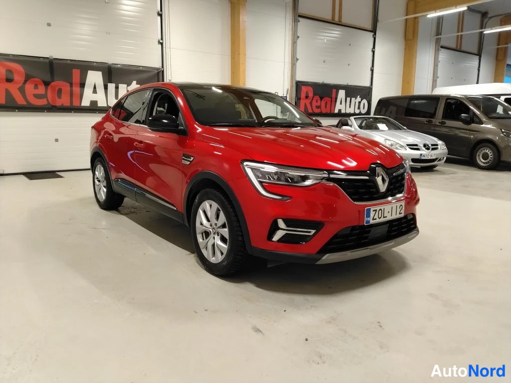 Etuviisto, nokka oikealle: Punainen Renault Arkana etukulmasta oikealta hallitilassa, rekisterikilpi.