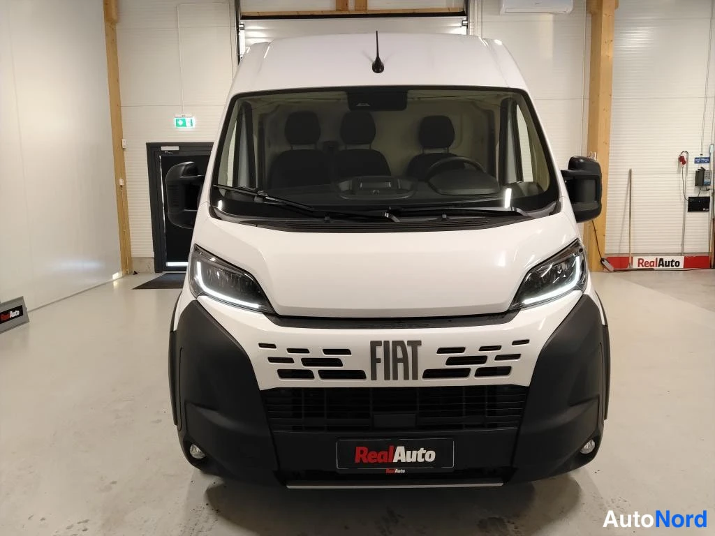 Edestä: Fiat Ducato -pakettiauto suoraan edestä valkoisena sisätiloissa.