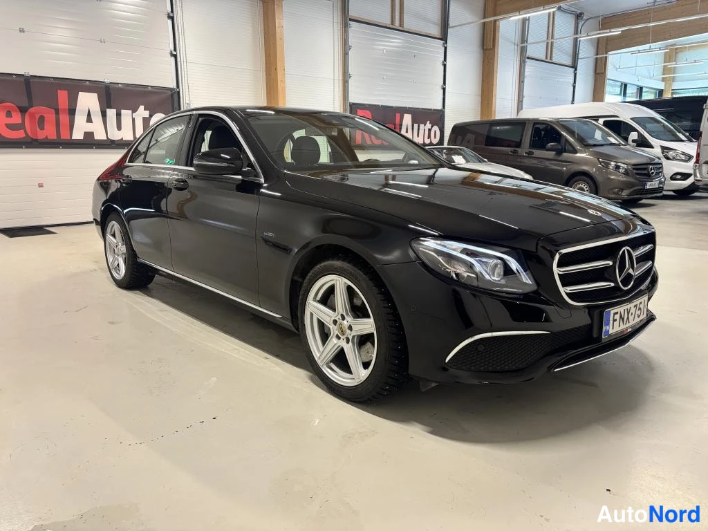 Etuviisto, nokka oikealle: Mustan Mercedes-Benzhenkilöauton etukulma oikealta, rekisteritunnus, hopeavanteet.