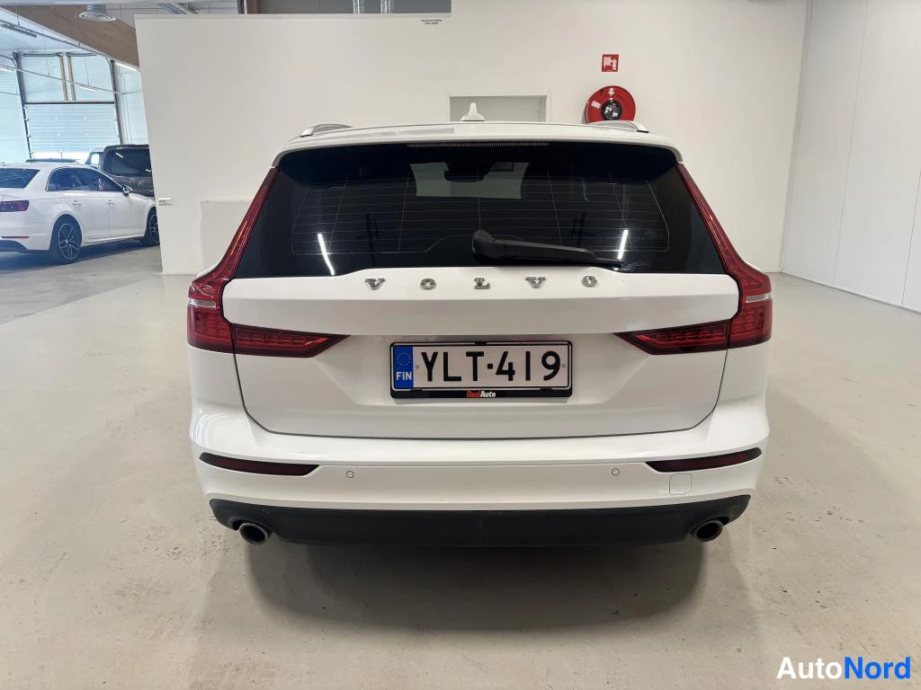 Takaa: Valkoisen auton takanäkymä, VOLVO-teksti ja rekisterikilpi.