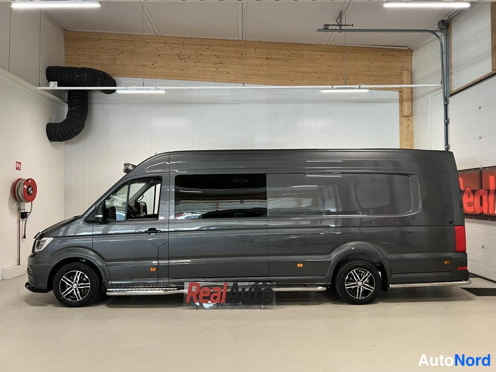 Sivulta: Tummanharmaan Volkswagen Crafter -pakettiauton sivukuva, joka näyttää auton pitkän kyljen, replayhyt ja suljetut takaovet.