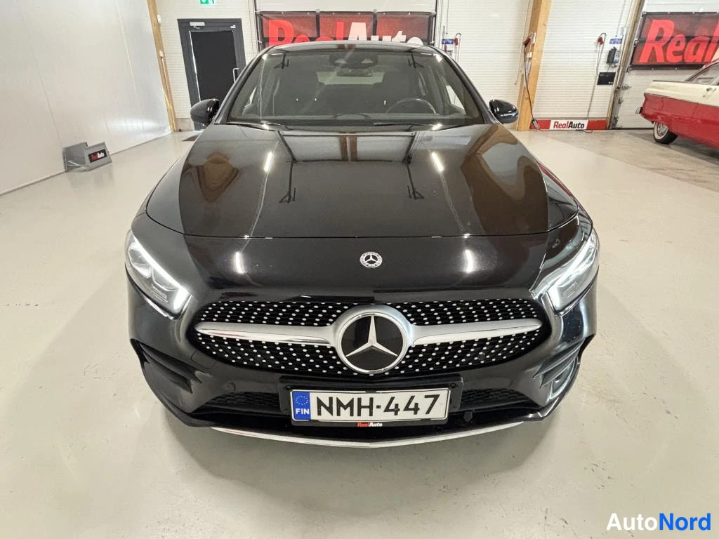Edestä: Mustan Mercedes-Benz A -sedanin etunäkymä suoraan edestä, rekisterikilpi.