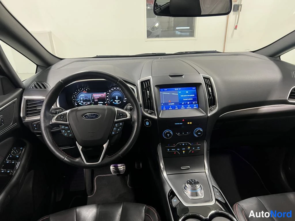 Etuviisto: Ford-ohjauspyörä, mittaristo ja infotainment-näyttö kartalla, keskikonsoli ja vaihtimen valitsin.