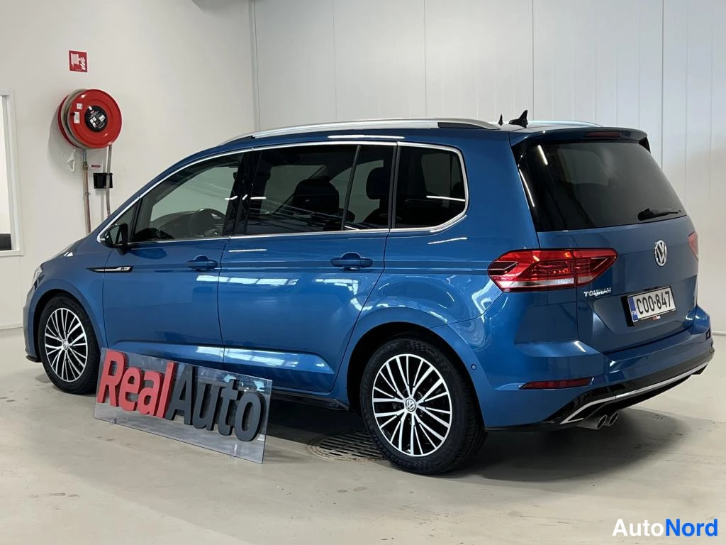 Takaviisto: Sininen tila-auto takimmaisesta kolmasosakulmasta, takapovi ja kylki näkyvissä.
