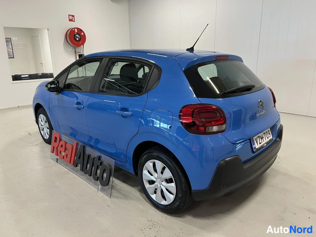 Takaviisto: Sininen Citroën C3 takakulmasta sisätiloissa.
