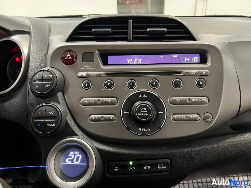 Muu: Auton kojelaudan keskusyksikkö: radiovälineistö, nappulat ja ilmastoinnin AUTO 20 -näyttö.