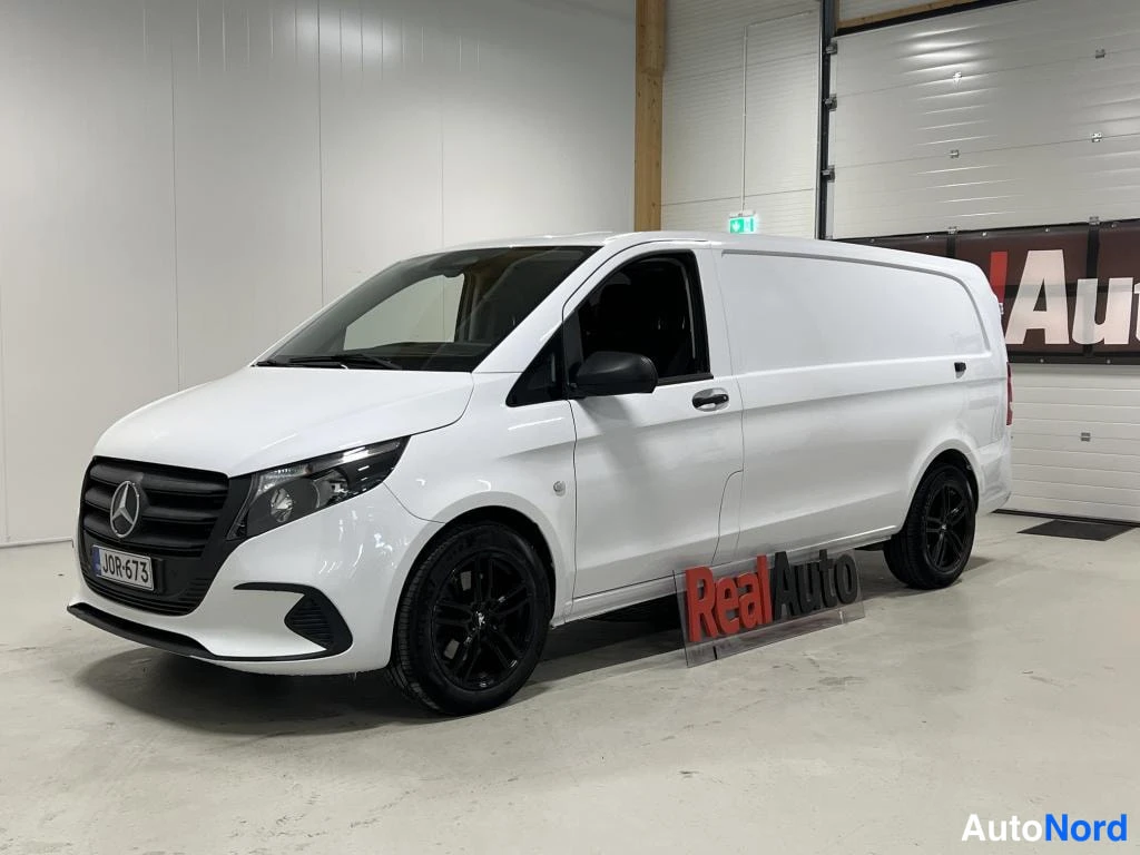 Etuviisto, nokka vasemmalle: Mercedes-Benz Vito -pakettiauto valkoisena etukulmasta autotallissa, mustat vanteet ja tummat ikkunat.