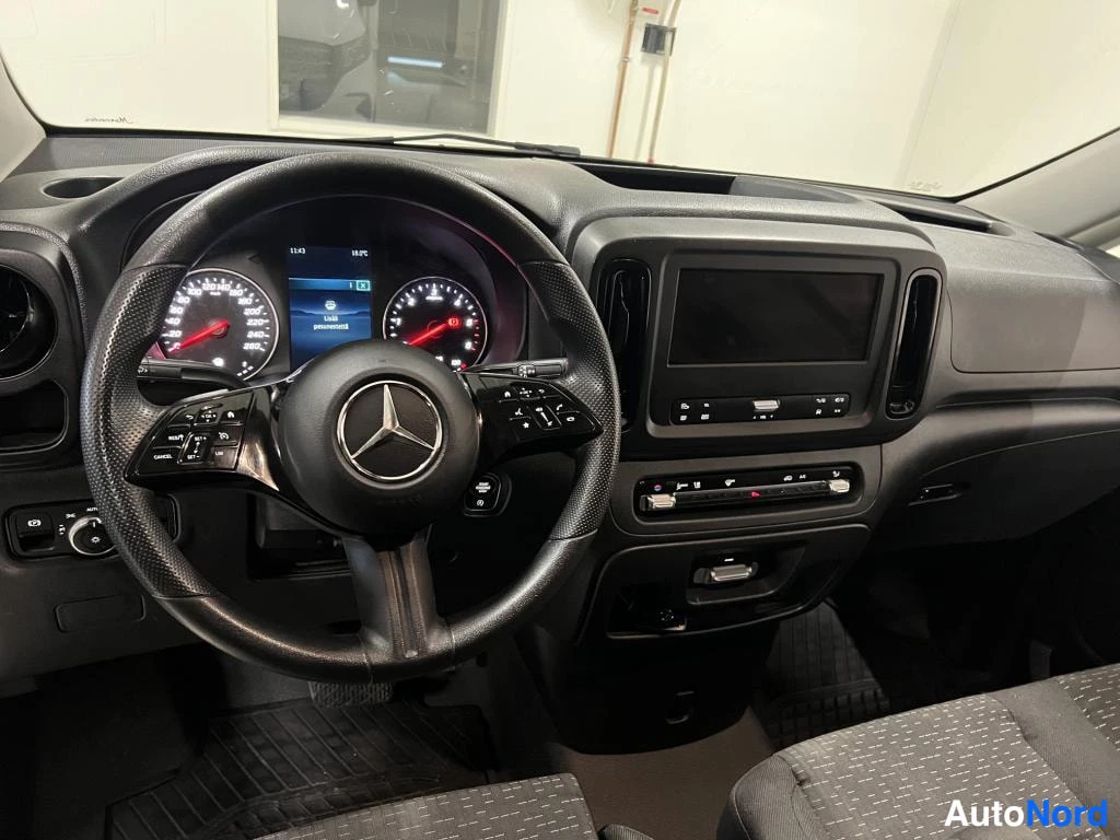 Yksityiskohta: Mercedes-henkilöauton ohjaamo: ohjauspyörä, digitaalinen mittaristo ja keskikonsolin näyttö