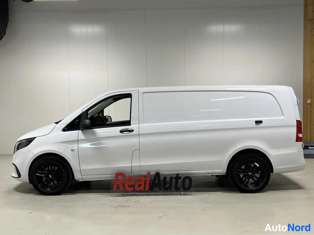 Sivulta: Mercedes-Benz Vito -pakettiauto valkoisena sivulta sisätiloissa, mustat vanteet ja tummat ikkunat.