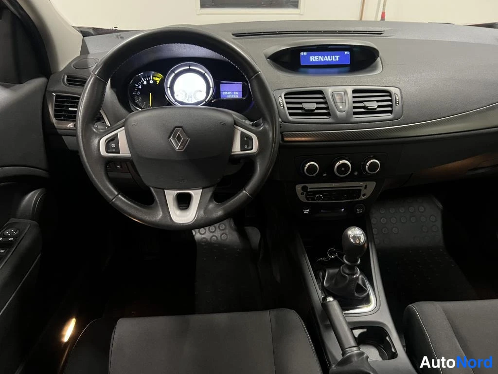 Muu: Renaultin kojelauta ja ohjauspyörä, näytössä teksti RENAULT, manuaalivaihteiston vaihdekeppi ja keskikonsolin säätimet.