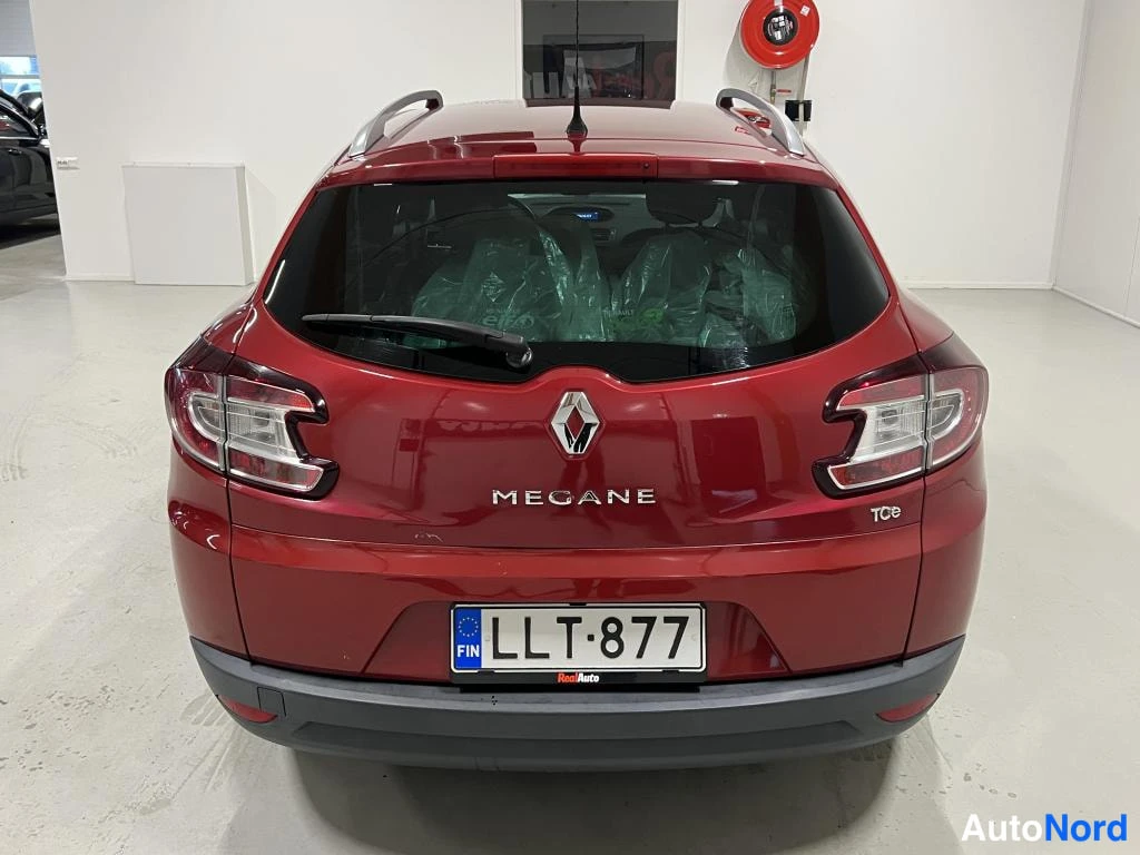Takaa: Punaisen Renault Meganen takapää; takavalot, MEGANE-teksti ja rekisteritunnus näkyvät.