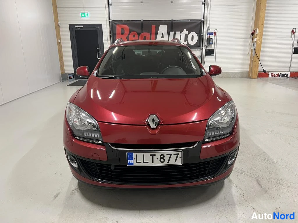 Edestä: Punaisen Renault-henkilöauton etunäkymä, rekisterikilpi, kuvattu sisätilassa.