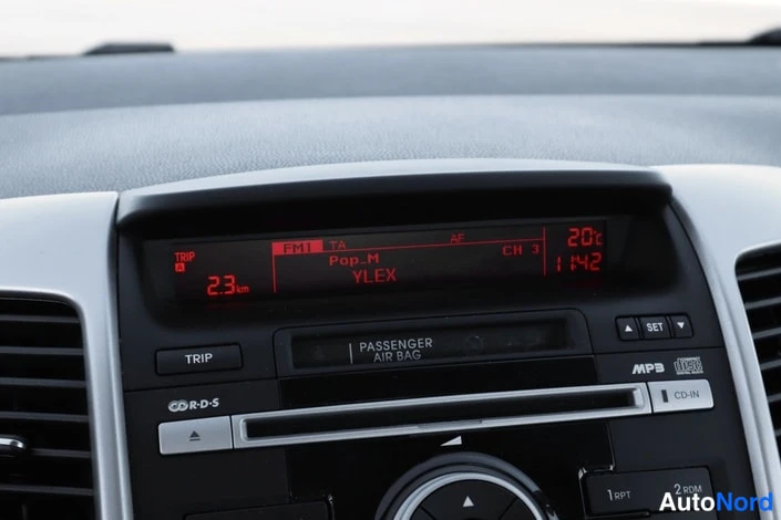 Muu: Auton kojelaudan radiopaneeli, infonäytössä kanava Pop_M YLEX, lämpötila 20 astetta ja kello 1:42.