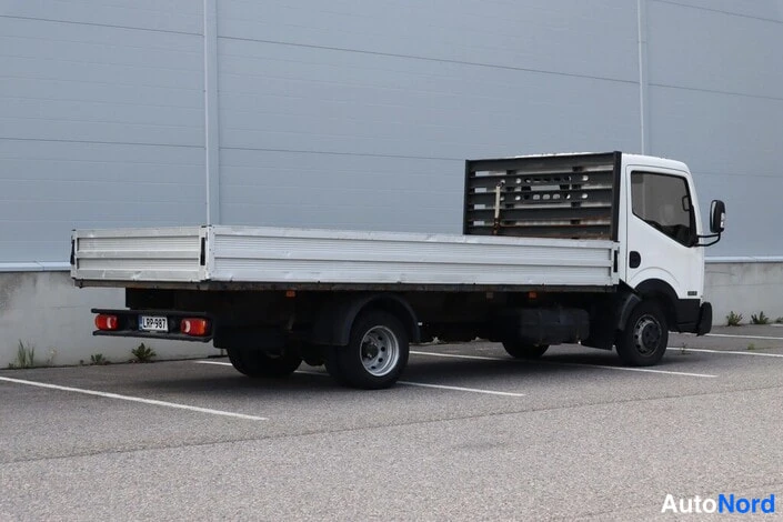 Takaviisto: Takaviistossa valkoinen lava-auto, rekisterikilpi ja takavalot näkyvät.