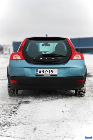 Takaa: Auton takaosan suorakuva lumessa; takaluukussa VOLVO-teksti, rekisterikilpi, pyörät osittain lumen peitossa.