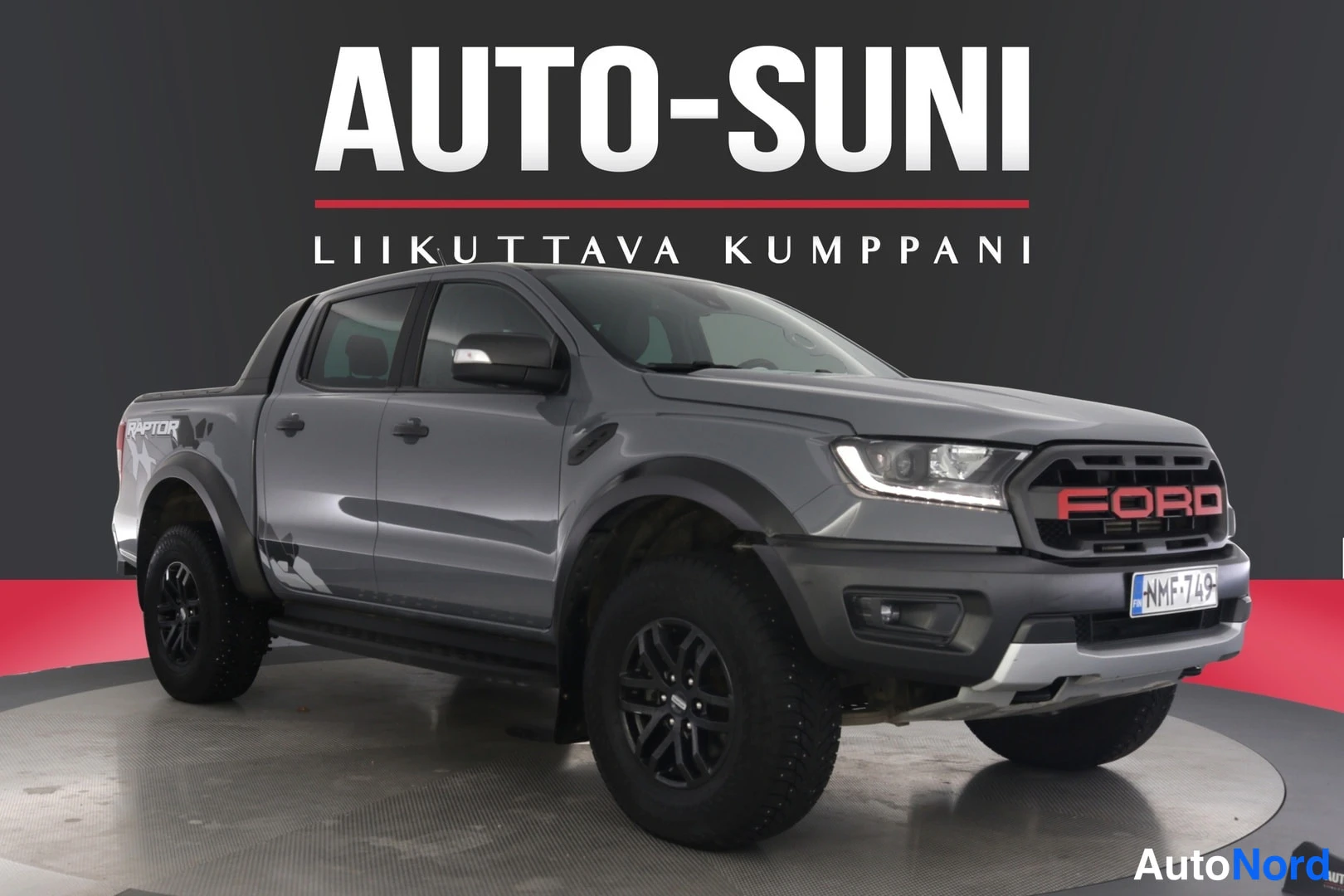 Etuviisto, nokka oikealle: Harmaa Ford Ranger -mallinen avolava-auto, etukulmanäkymä, nokka kuvan oikeassa reunassa.
