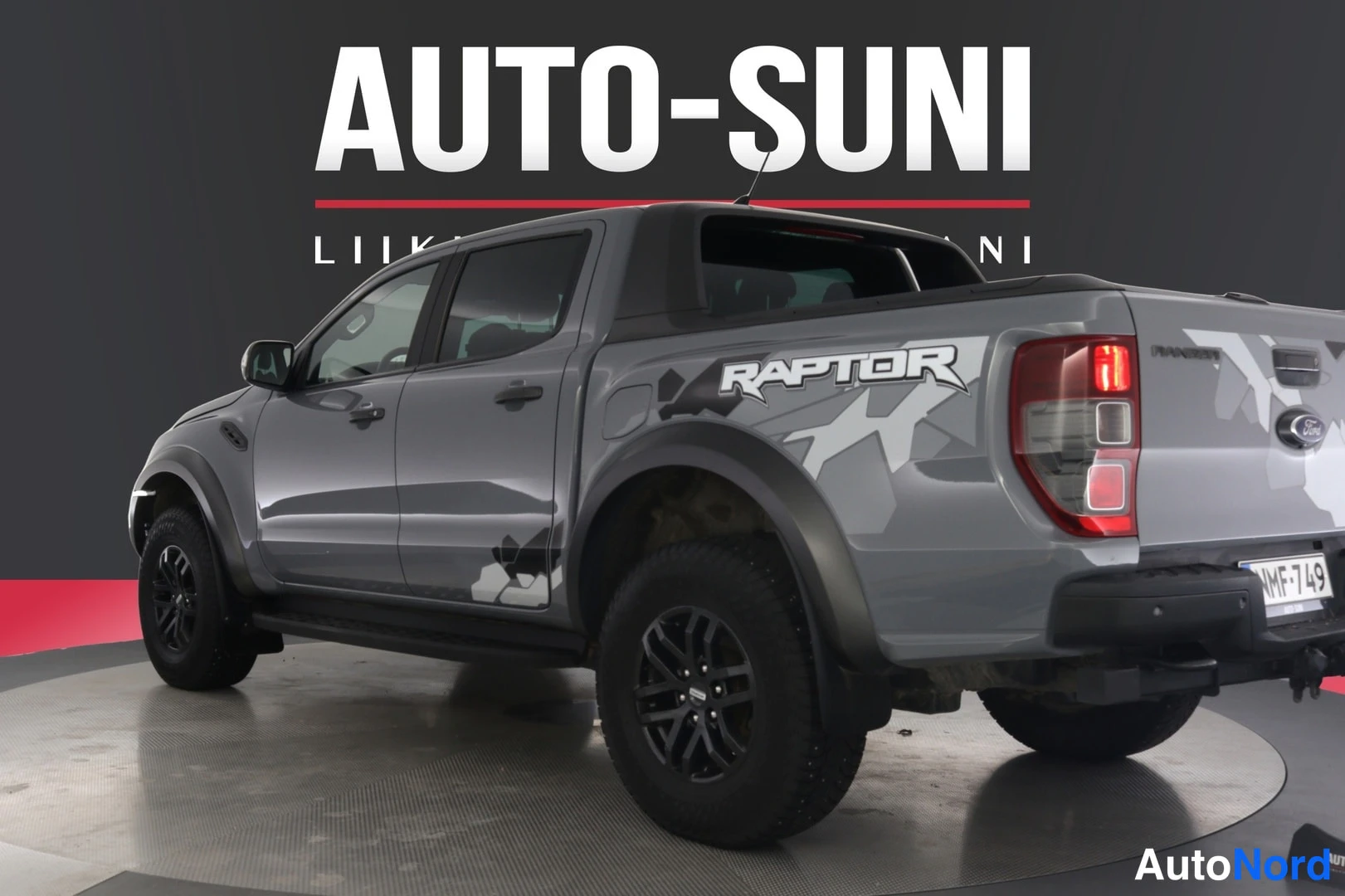 Takaviisto: Harmaa Ford Ranger -mallinen avolava-auto, takakulmanäkymä, takapää kuvan oikeassa reunassa.