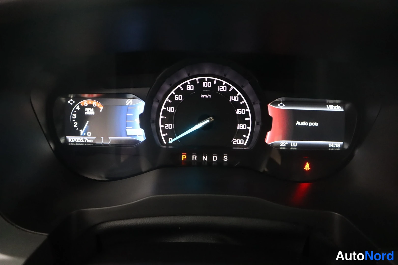 Muu: Kojetaulun mittaristo: nopeusmittari asteikolla 0–200 km/h, kierrosmittari, näytöllä lukemat 107035,7 km ja 'Audio pois', vaihdevalinnat P R N D S.