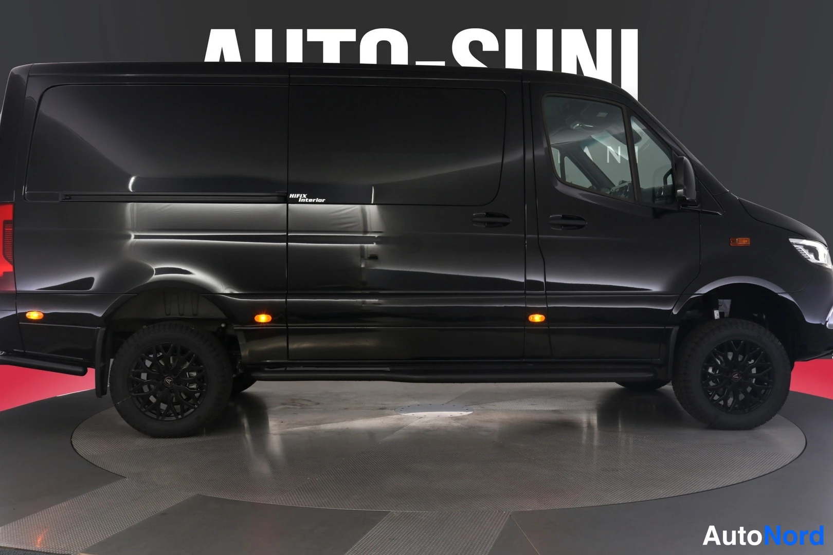 Etuviisto, nokka oikealle: Musta Mercedes-Benz Sprinter -pakettiauto sivusuunnasta kuvattuna, tummat vanteet ja mustat astinlaudat.