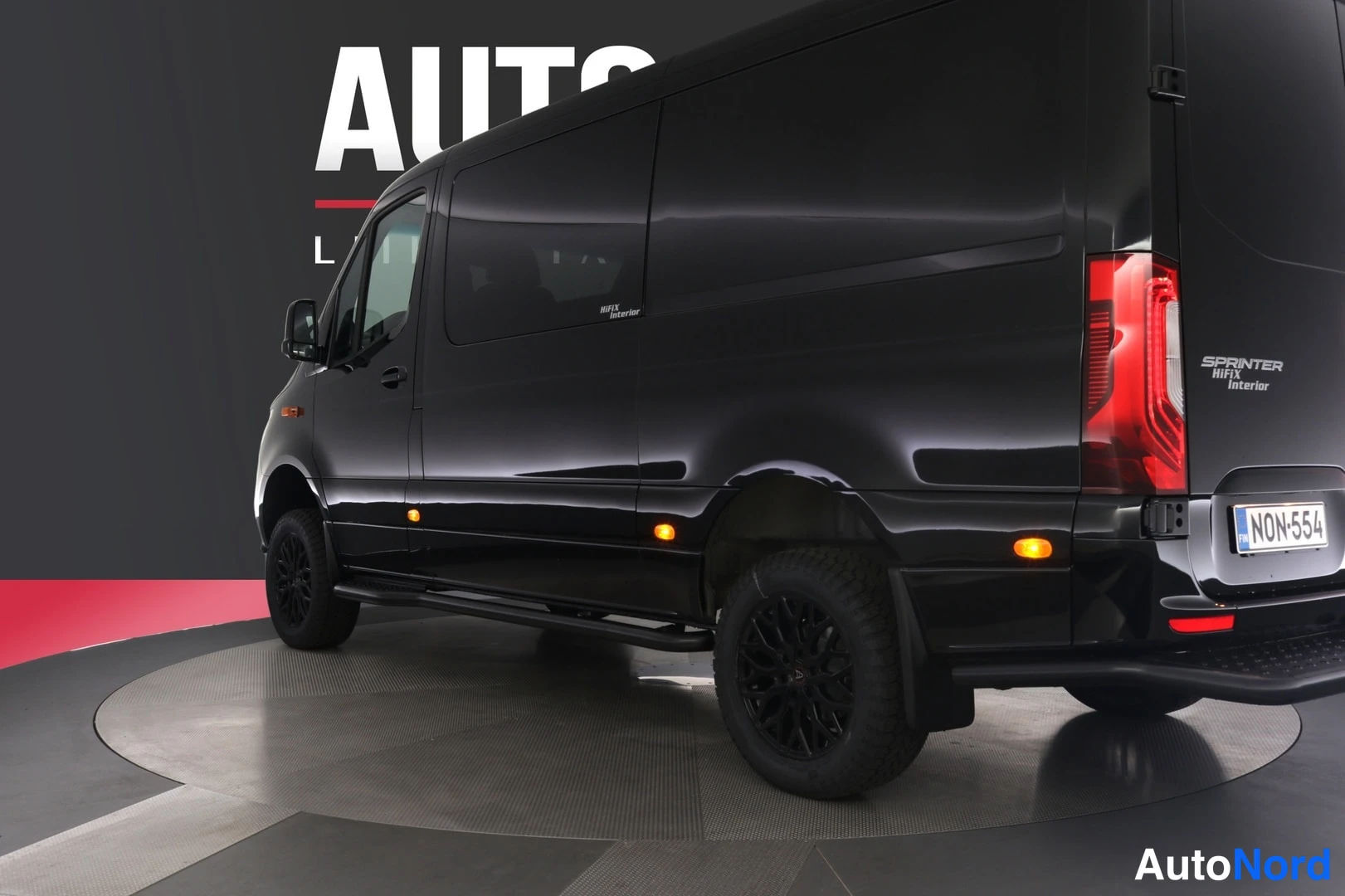 Takaviisto: Musta Mercedes-Benz Sprinter -pakettiauto takaa kolmanneksesta vasemmalta, peräosat ja rekisterikilpi näkyvät.