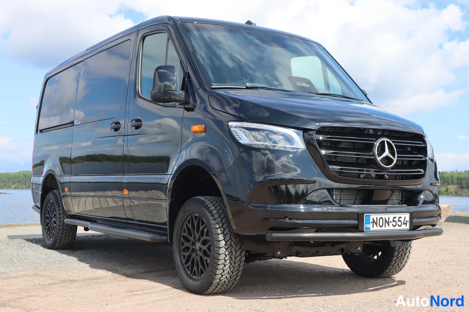 Etuviisto, nokka oikealle: Musta Mercedes-Benz Sprinter -pakettiauto kuvattu etukulmasta oikealta, keula ja vasen sivu näkyvät.