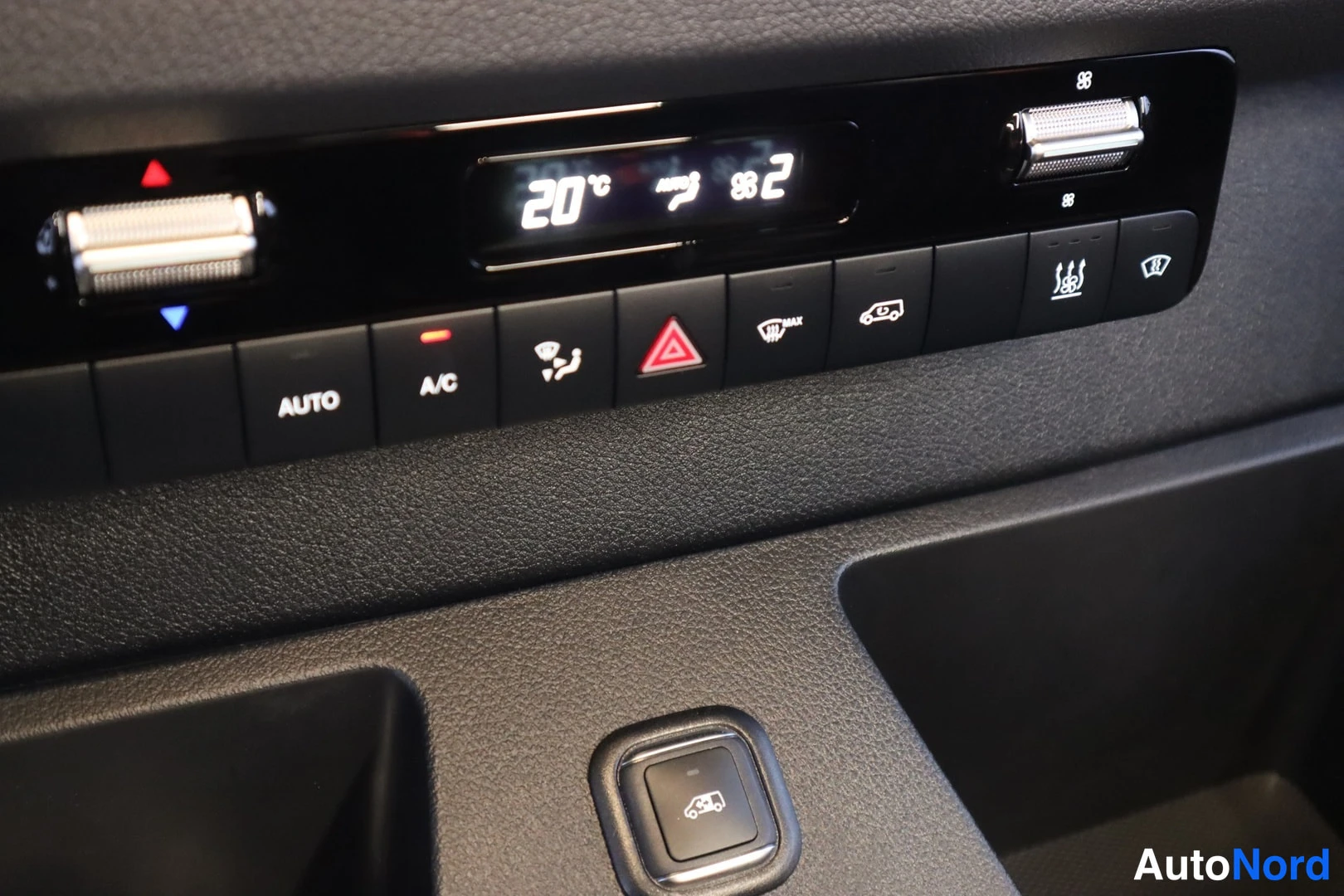 Muu: Tallenne: kojelaudan ilmastointipaneeli, näppäimet AUTO ja A/C, lämpötila 20 °C.