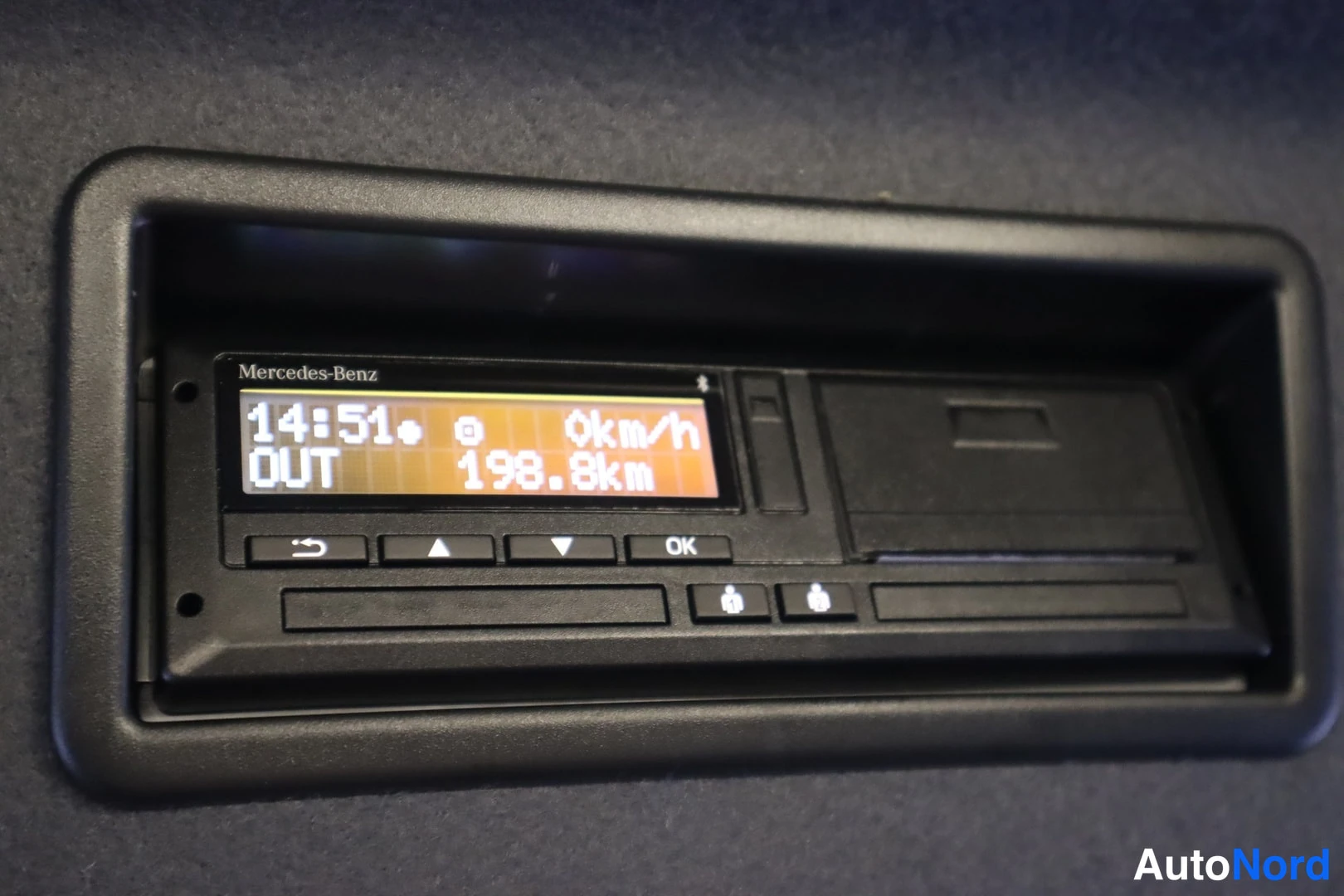 Muu: Mercedes-Benzin kojelaudan pieni näyttö, joka näyttää kellon 14:51, nopeuden 0 km/h ja lukeman 198.8 km.