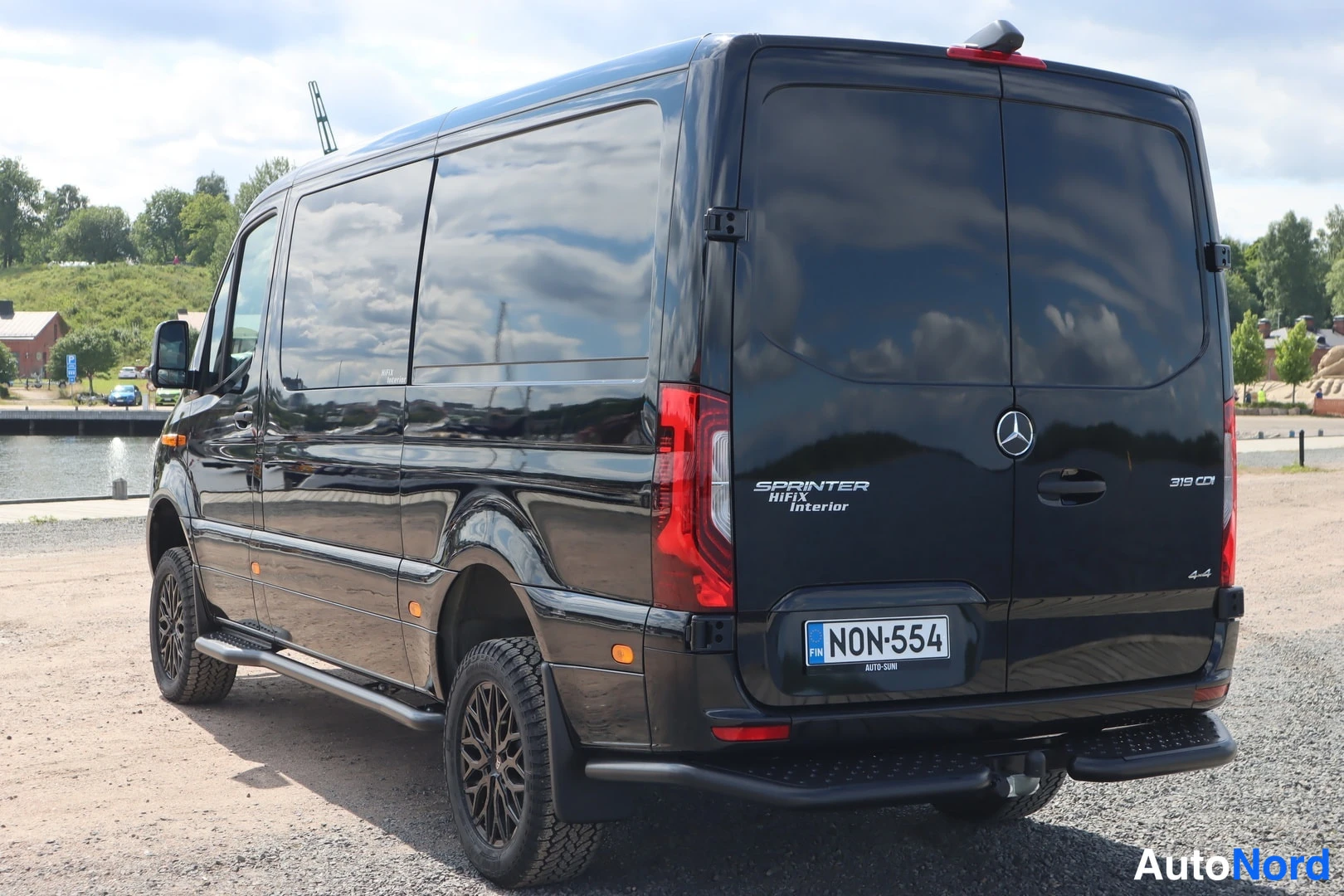 Takaviisto: Musta Mercedes-Benz Sprinter -pakettiauto takaa-suunnasta vasemmasta kulmasta kuvattuna, rekisterikilpi.