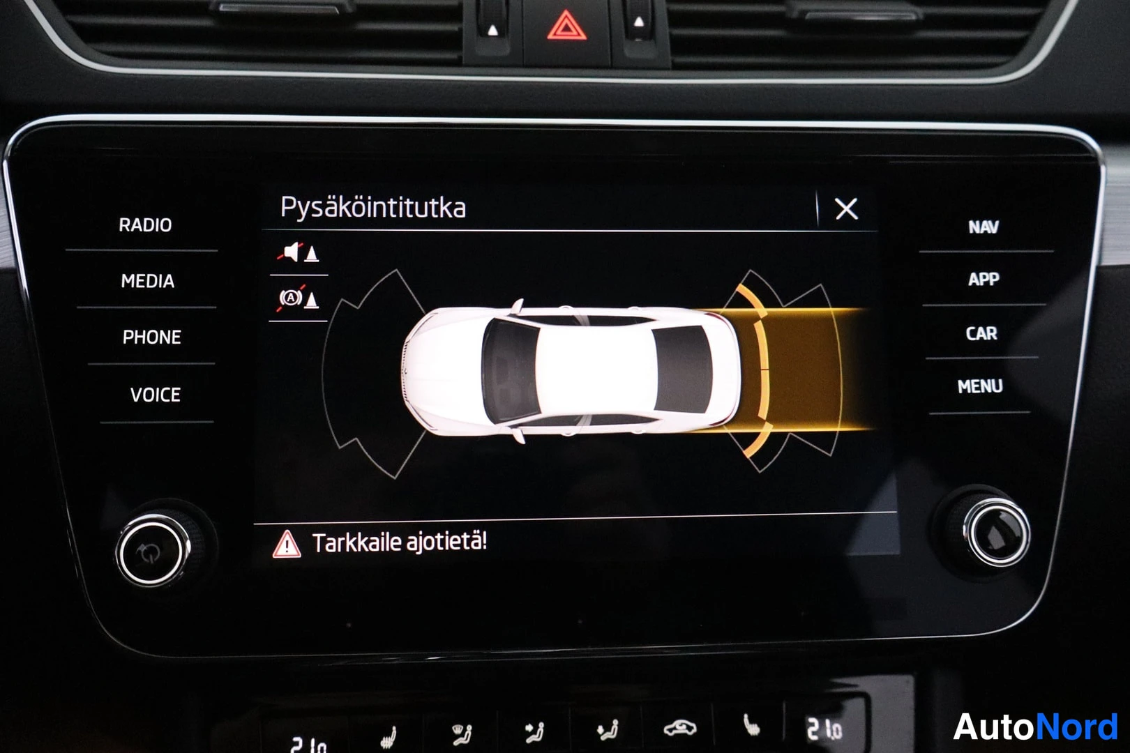 Ohjaamo: The central infotainment touchscreen displays the top-down graphic interface for the parking radar system, with the title 'Pysäköintitutka' visible at the top.